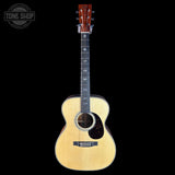Acoustic guitar with a visible brand logo on a black background