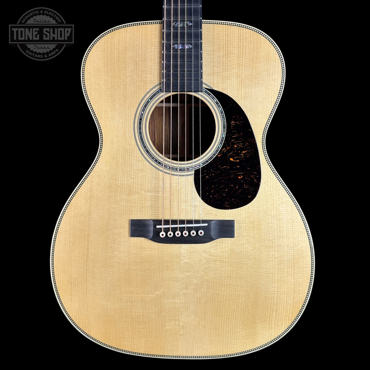 Acoustic guitar with a visible brand logo on a black background
