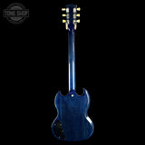 The back view of a blue electric guitar with a glossy blue finish, shown against a solid black background. A Tone Shop watermark is visible in the top-left corner.