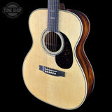 Acoustic guitar with a visible brand logo on a black background