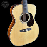 Acoustic guitar with a visible brand logo on a black background