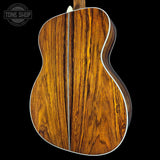 Close-up of a wooden acoustic guitar with a visible brand logo in the corner.