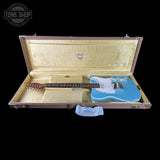 Blue electric guitar in an open Fender case with 'Tone Shop' logo.