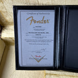 Fender certificate of authenticity in a black leather holder on a textured surface