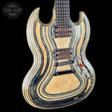 A custom electric guitar with a wavy, striped natural wood and black laminated body, shown against a solid black background. The brand 'Tone Shop' is visible as an overlay in the top left corner.