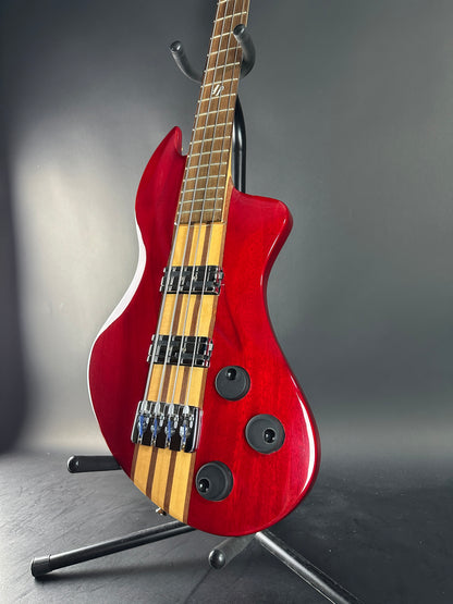 Red electric bass guitar on a gray background
