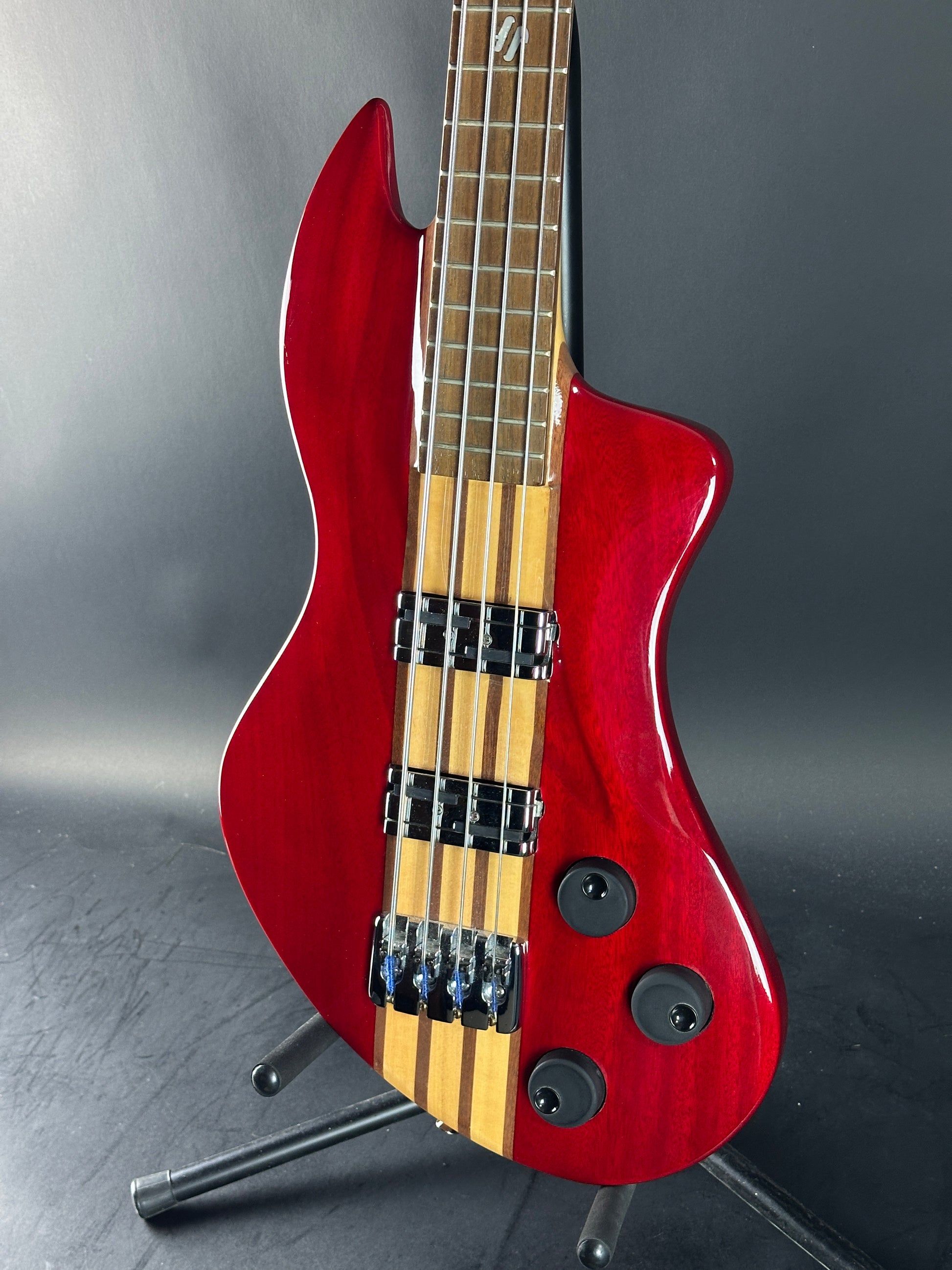 Red electric bass guitar on a gray background