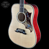 An acoustic guitar with a natural wood top, a red cherry wood side, and detailed bird inlays on the pickguard and headstock, shown against a black background with a Tone Shop watermark.