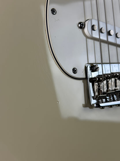Close-up of a guitar's bridge and strings on a beige background