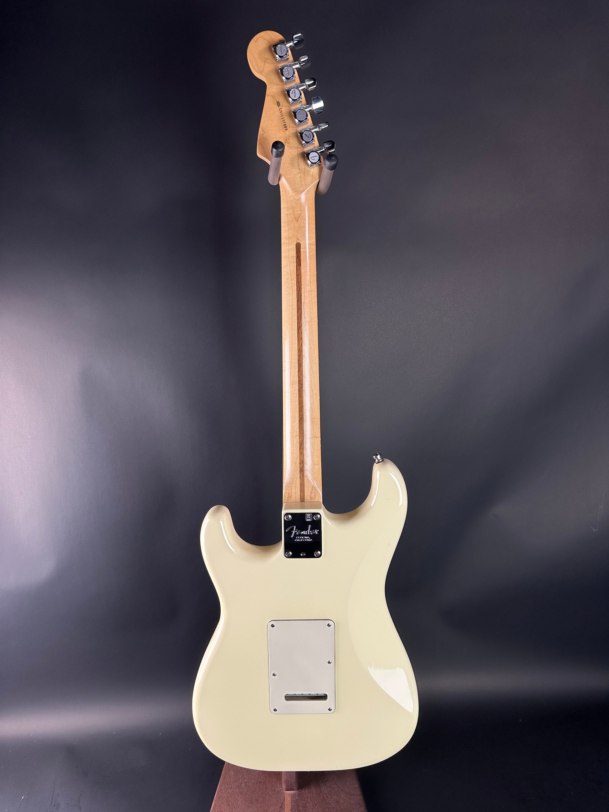 Electric guitar with a cream-colored body and wooden neck on a dark background