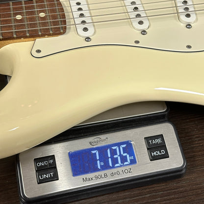 Electric guitar on a digital scale displaying weight