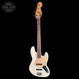 A white electric bass guitar with a natural wood body and neck, shown vertically against a solid black background. A Tone Shop watermark is visible in the top-left corner.
