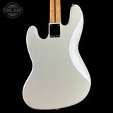 The rear view of a white electric guitar body with a maple neck, shown against a solid black background. A Tone Shop watermark is visible in the top-left corner.