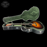 Guitar in a case with 'Tone Shop' logo in the corner