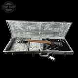 Guitar in an open case with 'Tone Shop' logo in the corner.