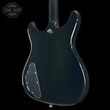 Glossy black electric guitar body on a black background with 'Tone Shop' logo.