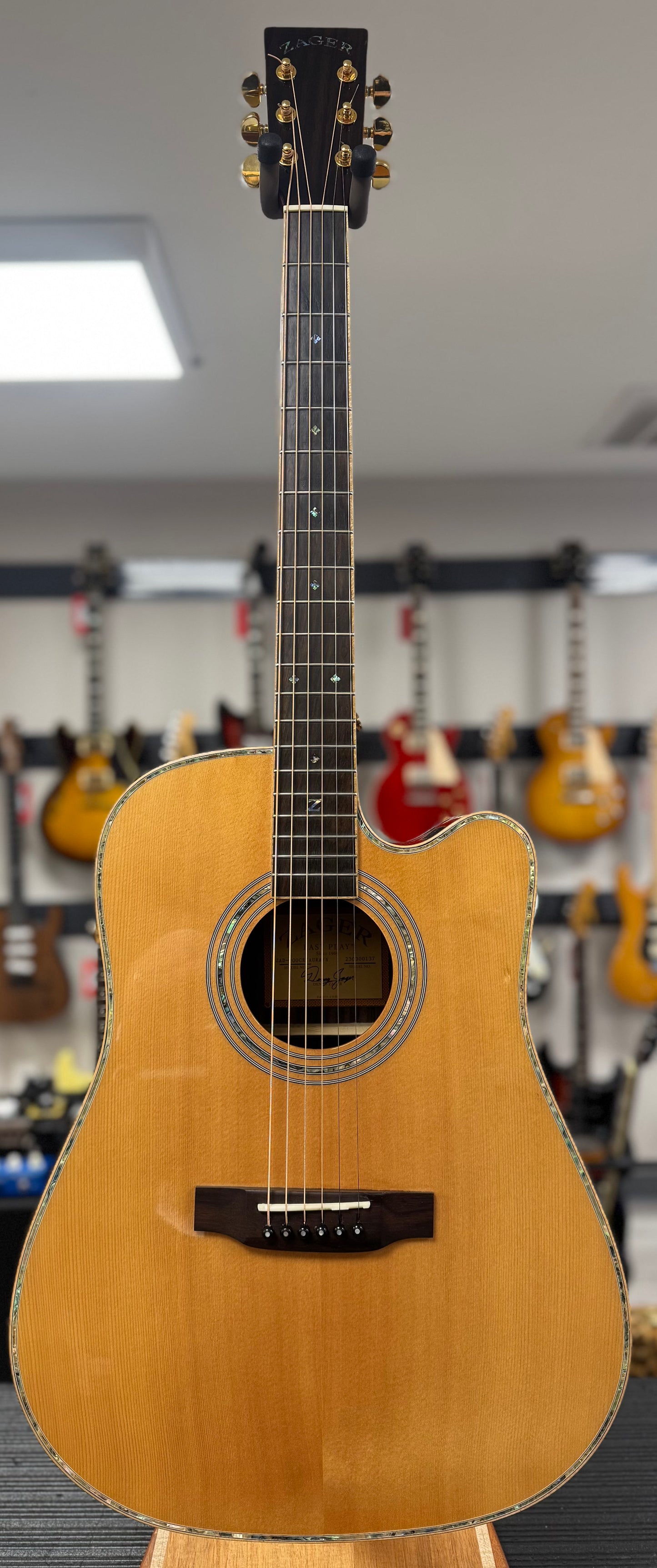 Acoustic guitar on display in a music store with other guitars in the background