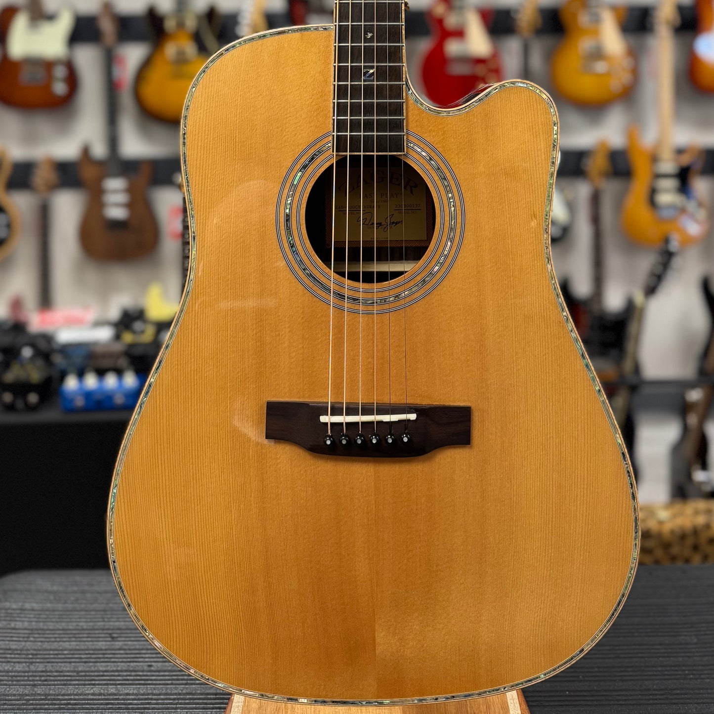 Acoustic guitar on display in a music store with other guitars in the background