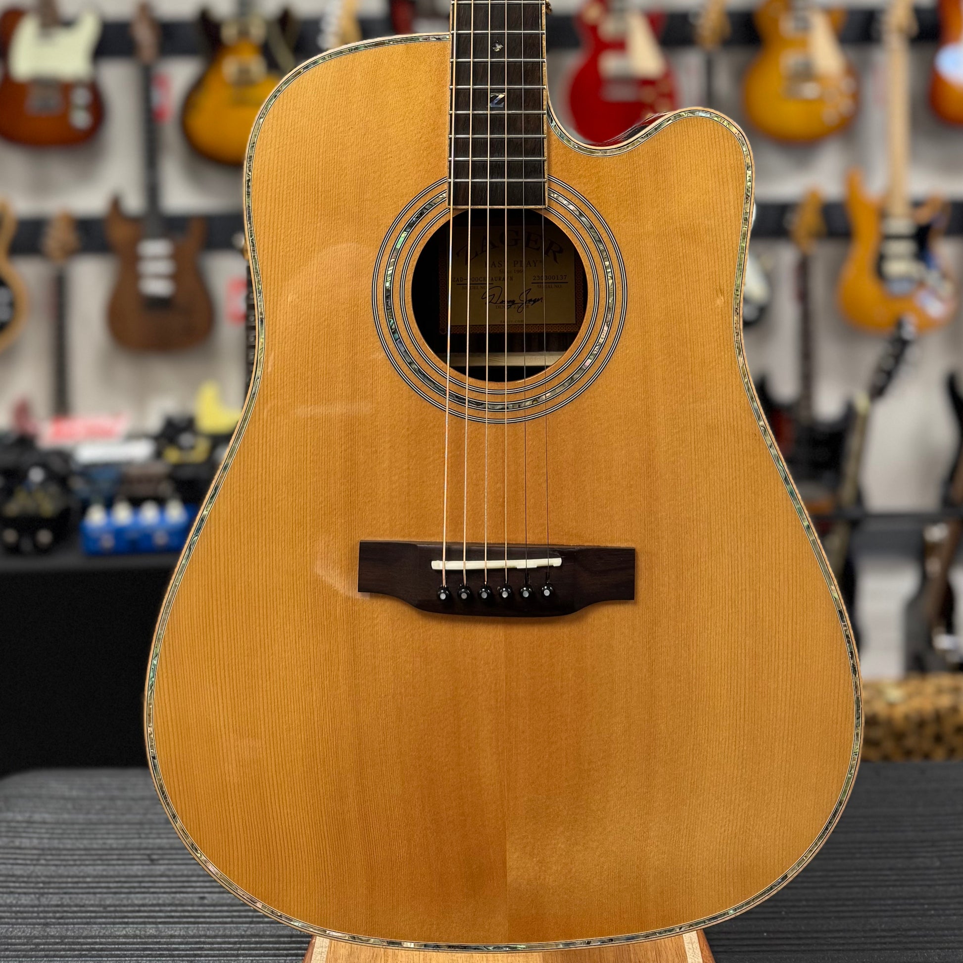 Acoustic guitar on display in a music store with other guitars in the background
