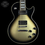 A Gibson Les Paul Custom electric guitar with a metallic gold-to-black gradient finish, shown from the front against a black background. The brand logo is visible on the headstock (partially cropped) and the body has white binding and black hardware.