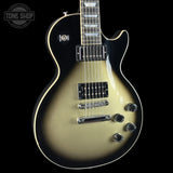 A Gibson Les Paul Custom electric guitar with a gold-to-black sunburst finish, featuring chrome hardware and a black pickguard, shown against a solid black background with a Tone Shop watermark in the top-left corner.