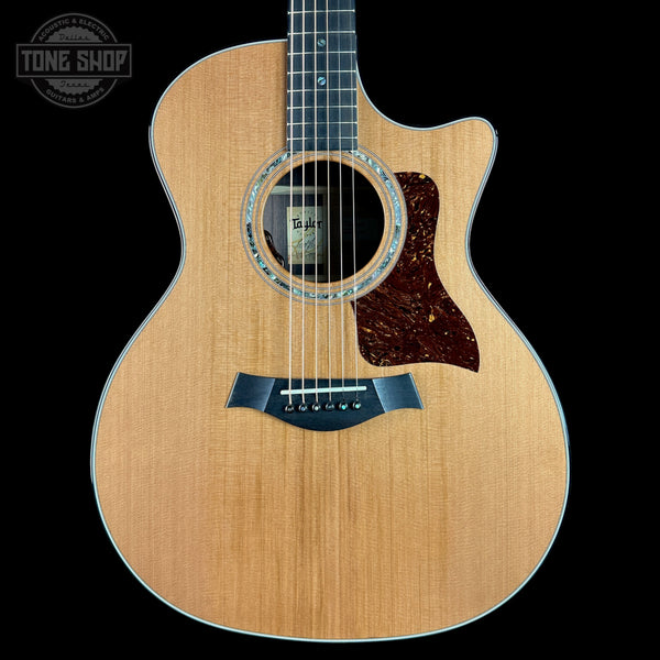 Acoustic guitar with a visible brand logo on a black background