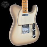 A classic Fender Telecaster electric guitar in a metallic champagne finish, shown from a front-three-quarter angle against a solid black background. The neck is made of natural maple wood, and the headstock is cropped out of the frame.