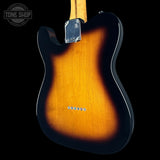 The back of a classic electric guitar with a sunburst finish, showing the warm amber-orange wood grain fading to black, photographed against a solid black background.