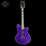 A purple electric guitar with a flamed maple body and black headstock, shown against a solid black background. A 'TONE SHOP' watermark is visible in the top-left corner.