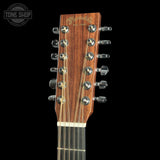 Close-up of the headstock of a Martin D-21 acoustic guitar, showing the brown wood grain, gold script branding, and silver tuning pegs against a black background.