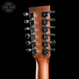 Close-up of the headstock of a guitar, showing two columns of six black tuners with silver screws and a warm brown wood finish, set against a solid black background. A Tone Shop watermark is visible in the top-left corner.