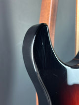 Close-up of a guitar's neck and headstock on a gray background