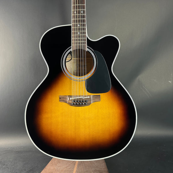 Acoustic guitar with black and brown finish on a gray background