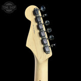 Close-up of a guitar headstock and neck joint showing a light natural wood finish, six black tuning pegs, and a Tone Shop watermark in the top left corner against a black background.