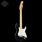 A black electric guitar with a white pickguard and maple neck, shown against a solid black background. A Tone Shop watermark is visible in the top-left corner.