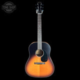 Acoustic guitar with a sunburst finish on a black background, featuring the Tone Shop logo.