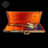 Guitar in an open case with a visible 'Tone Shop' logo.