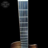Close-up of a guitar neck with a clear fretboard on a black background, featuring the Tone Shop logo.