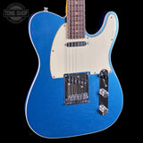 Blue electric guitar with a white pickguard on a black background, featuring the Tone Shop logo.