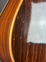 Close-up of a glossy dark brown wooden surface with visible wood grain, a light-colored edge trim, and a bright reflection near the top.