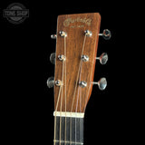 Close-up of the headstock of a Martin & Co acoustic guitar against a black background, showing the wooden headstock, six tuning pegs, and strings. A Tone Shop watermark is visible in the top left corner.