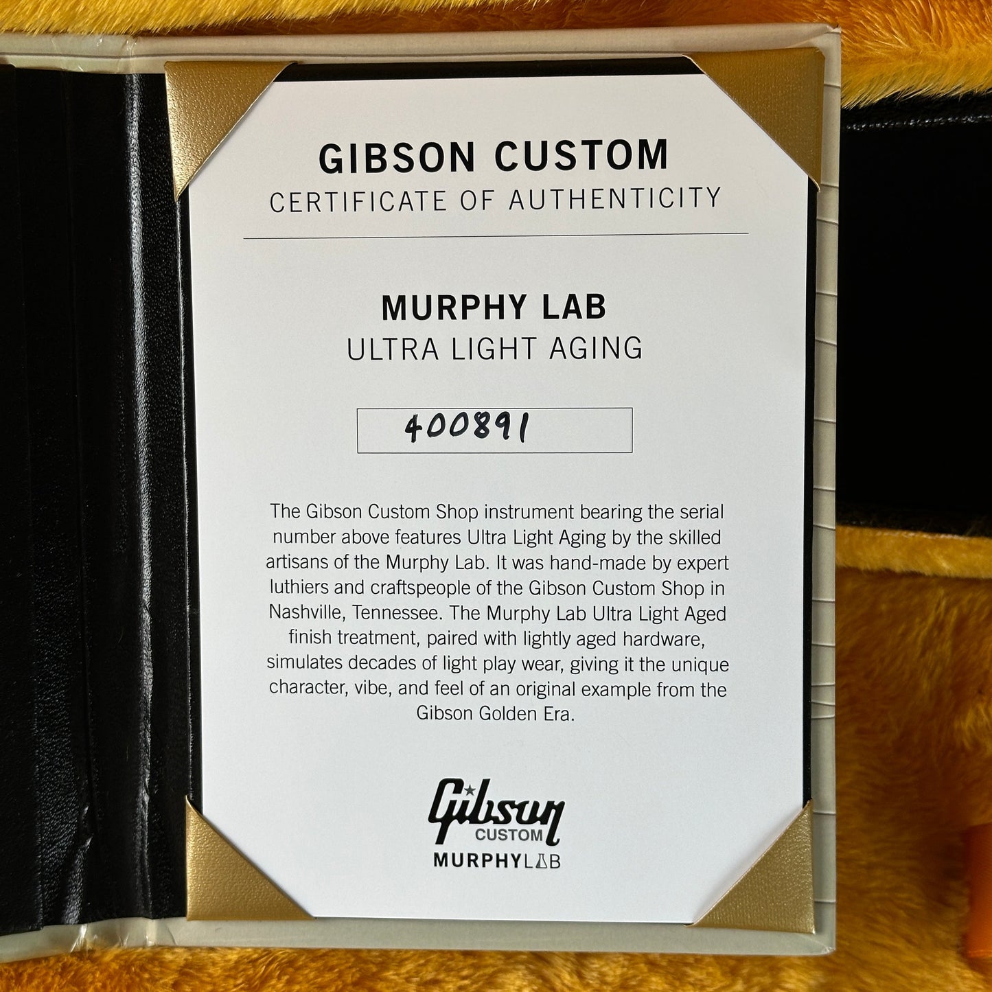 Gibson Custom Certificate of Authenticity for Murphy Lab Ultra Light Aging on a wooden surface.
