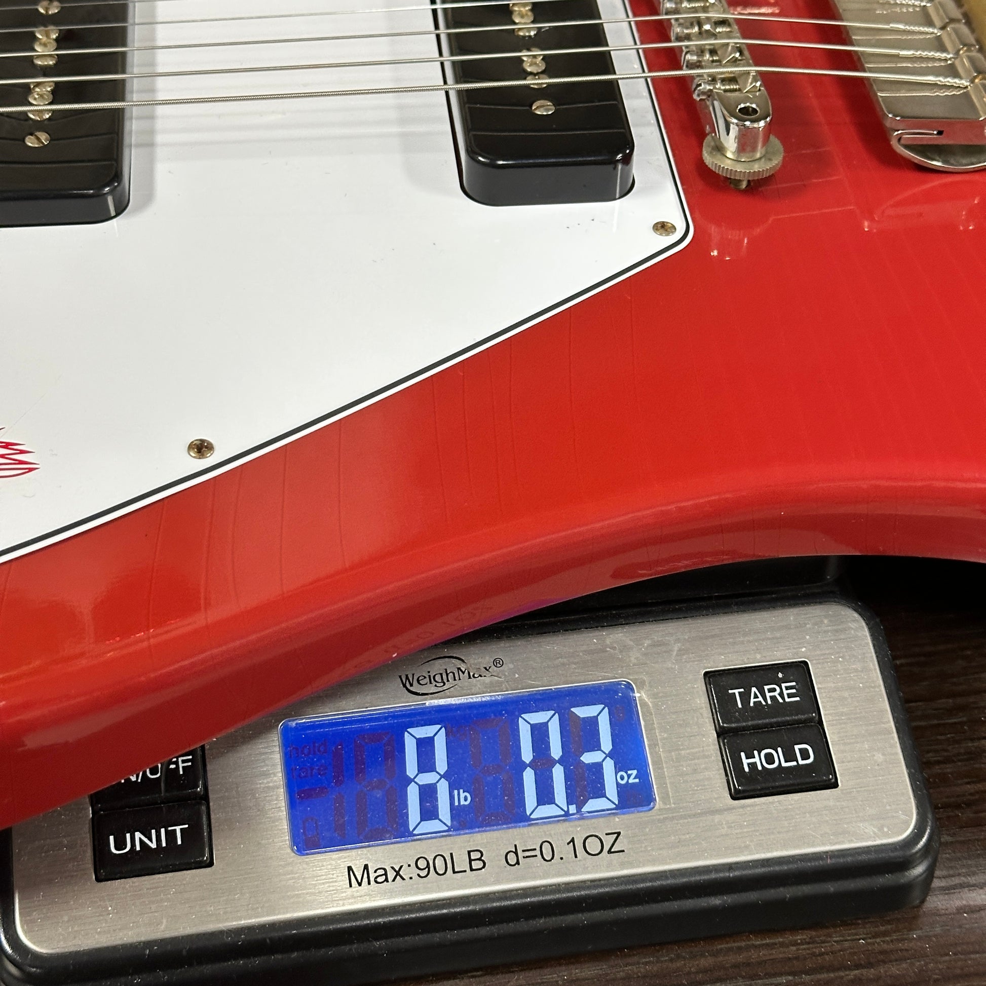 Gibson Custom Dealer Select 1965 Non Reverse Firebird Ember Red Ultra Light Aged on scale displaying weight.