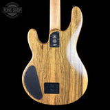 The back of a Yamaha electric guitar made of natural wood with a glossy finish, featuring a black pickguard and hardware, shown against a solid black background.