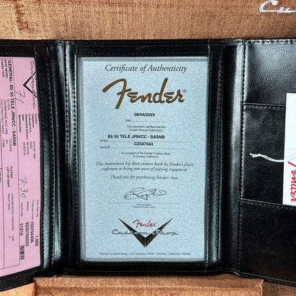 Fender certificate of authenticity inside a black leather case with a pink label.