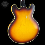 Close-up of the back of a classic electric guitar showing the sunburst finish, with a Tone Shop watermark in the top left corner.