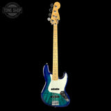 A Fender Jazz Bass electric guitar with a blue and green flamed maple top, a white pickguard, and a natural wood neck, shown against a solid black background with a Tone Shop watermark in the top left corner.