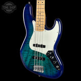 A four-string bass guitar with a vibrant blue and green flamed maple finish, a white pickguard, and a maple neck, shown against a black background with a Tone Shop watermark.