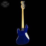 A blue electric bass guitar shown from the back against a solid black background, featuring a natural wood neck and headstock with four silver tuning pegs.