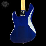 The back of a blue electric guitar with a maple neck, shown against a solid black background. A Tone Shop watermark is visible in the top left corner.